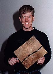 Jamie Paul holding piece of wood.